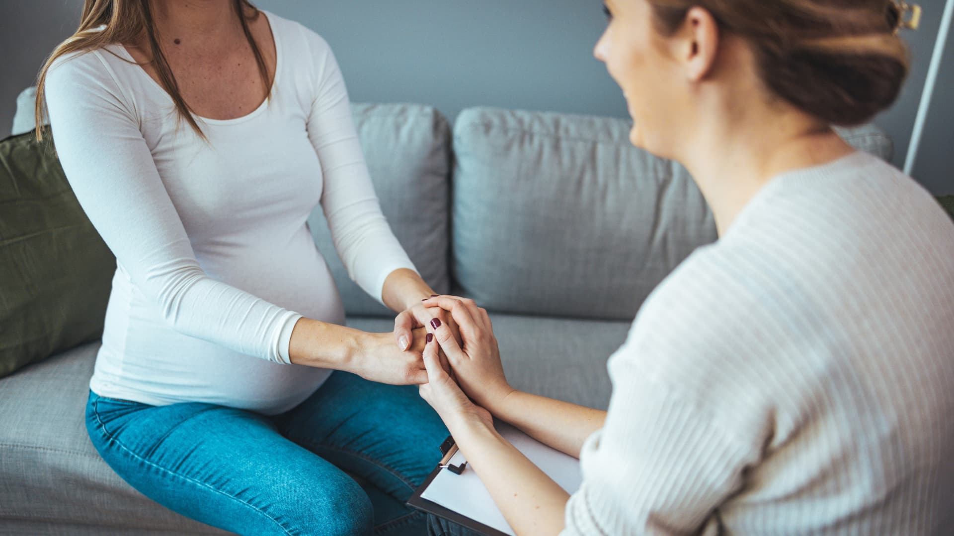 Counselor holding pregnant woman's hands