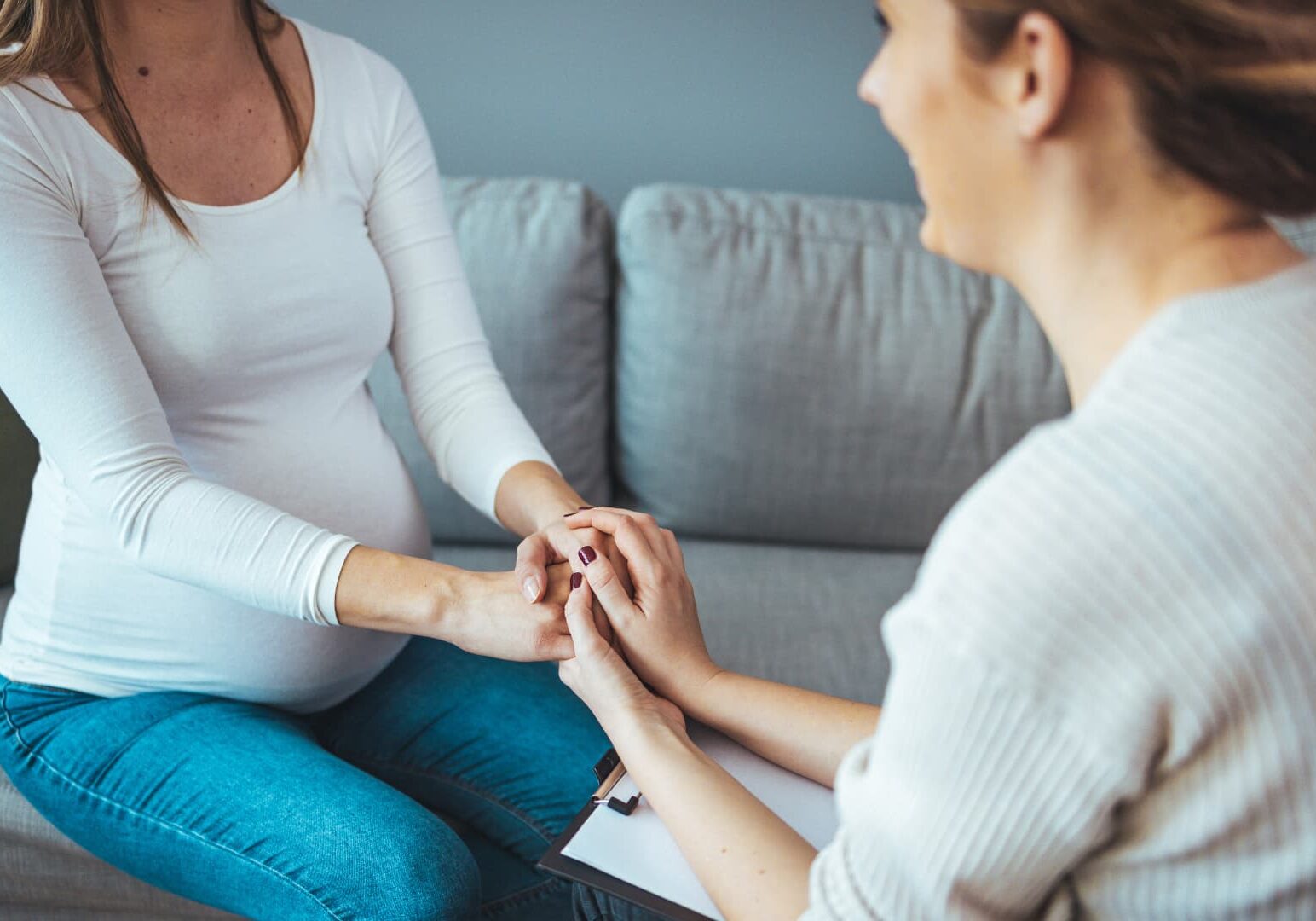Counselor holding pregnant woman's hands